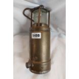 A vintage brass Oldham safety lamp