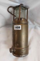 A vintage brass Oldham safety lamp
