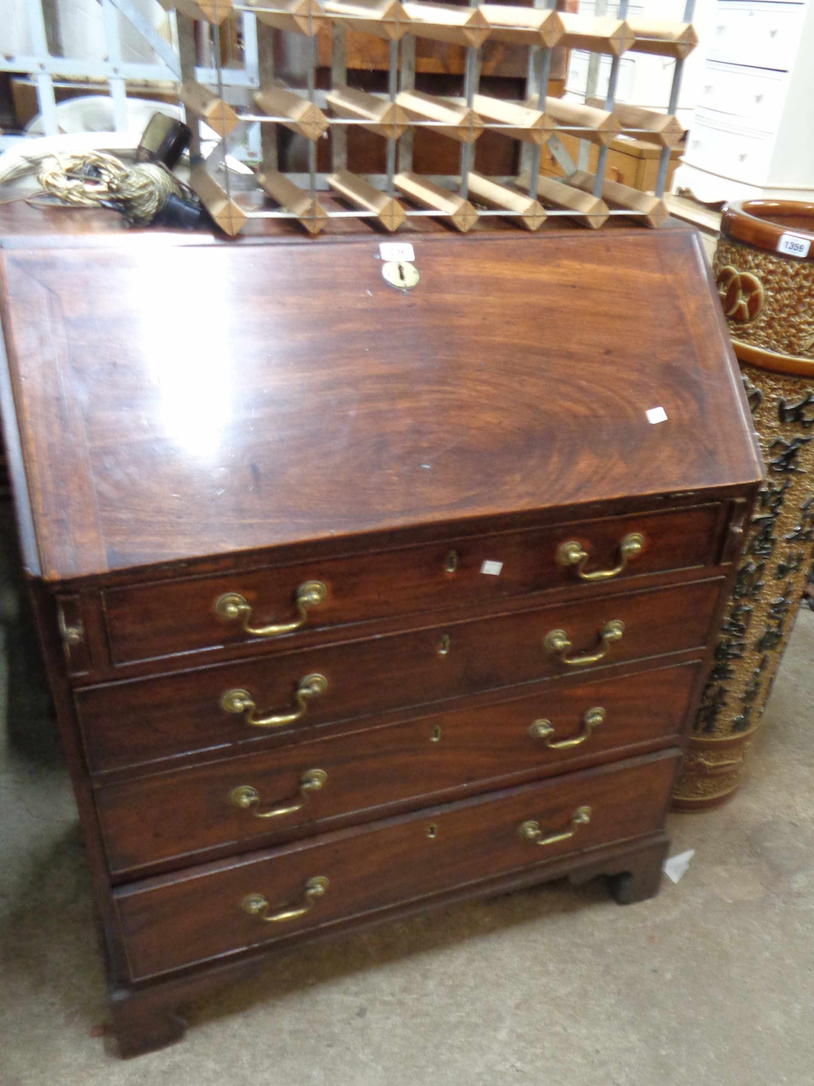 A 92cm late Georgian mahogany bureau with fitted interior and four long graduated drawers, set on