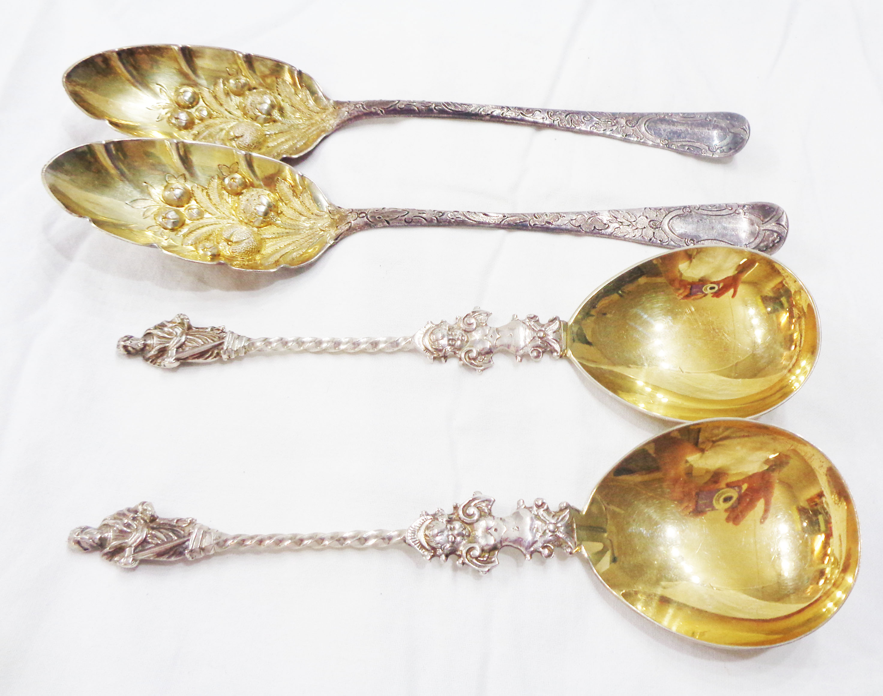 Two similar Georgian London silver tablespoons with later parcel gilt and berry decoration - sold