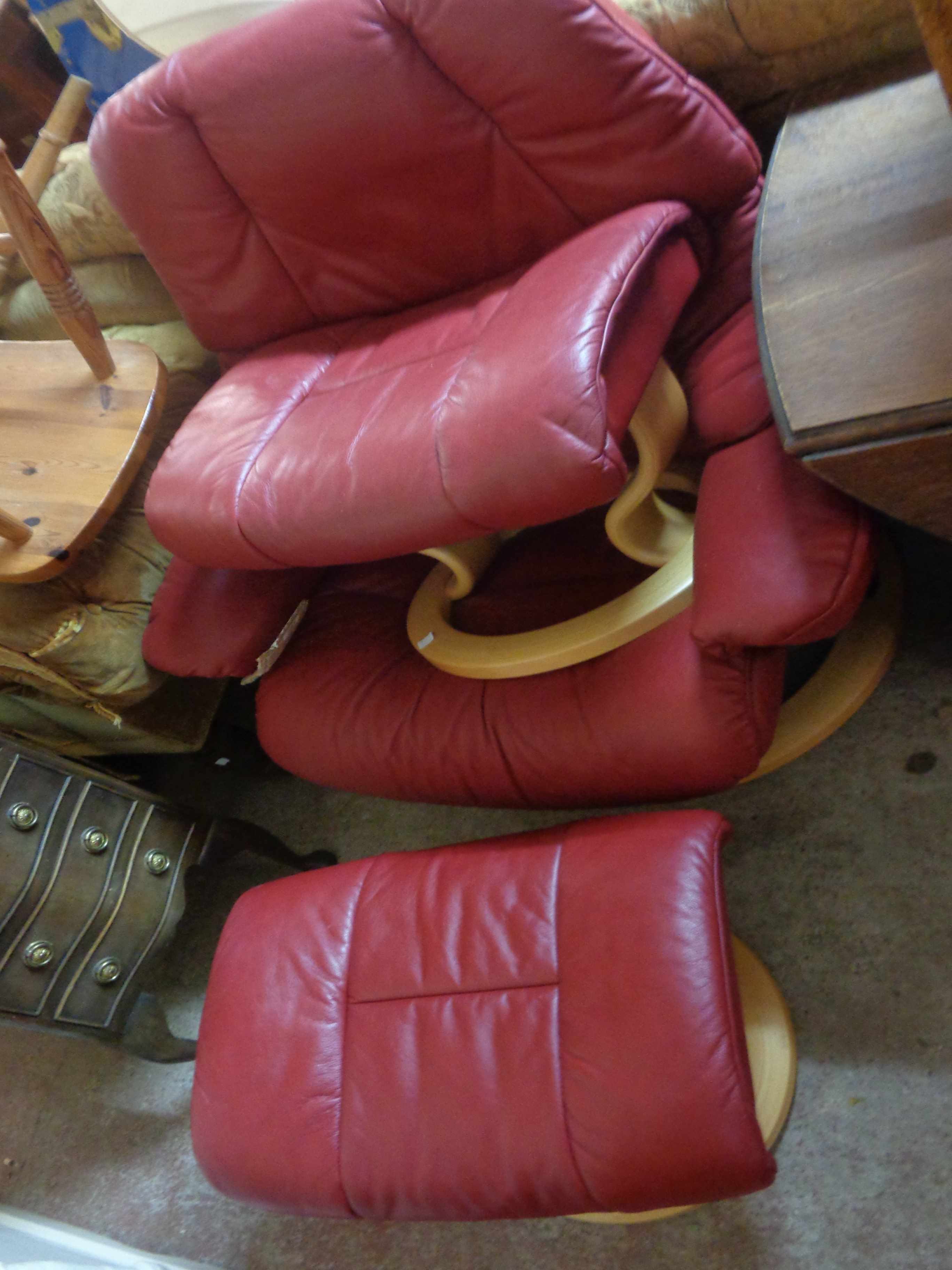 An Ekornes 'Stressless' easy chair upholstered in red leather and set on a bentwood swivel base -