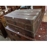 An 85cm old wood bound and weather coated travelling trunk with iron strapping and flanking