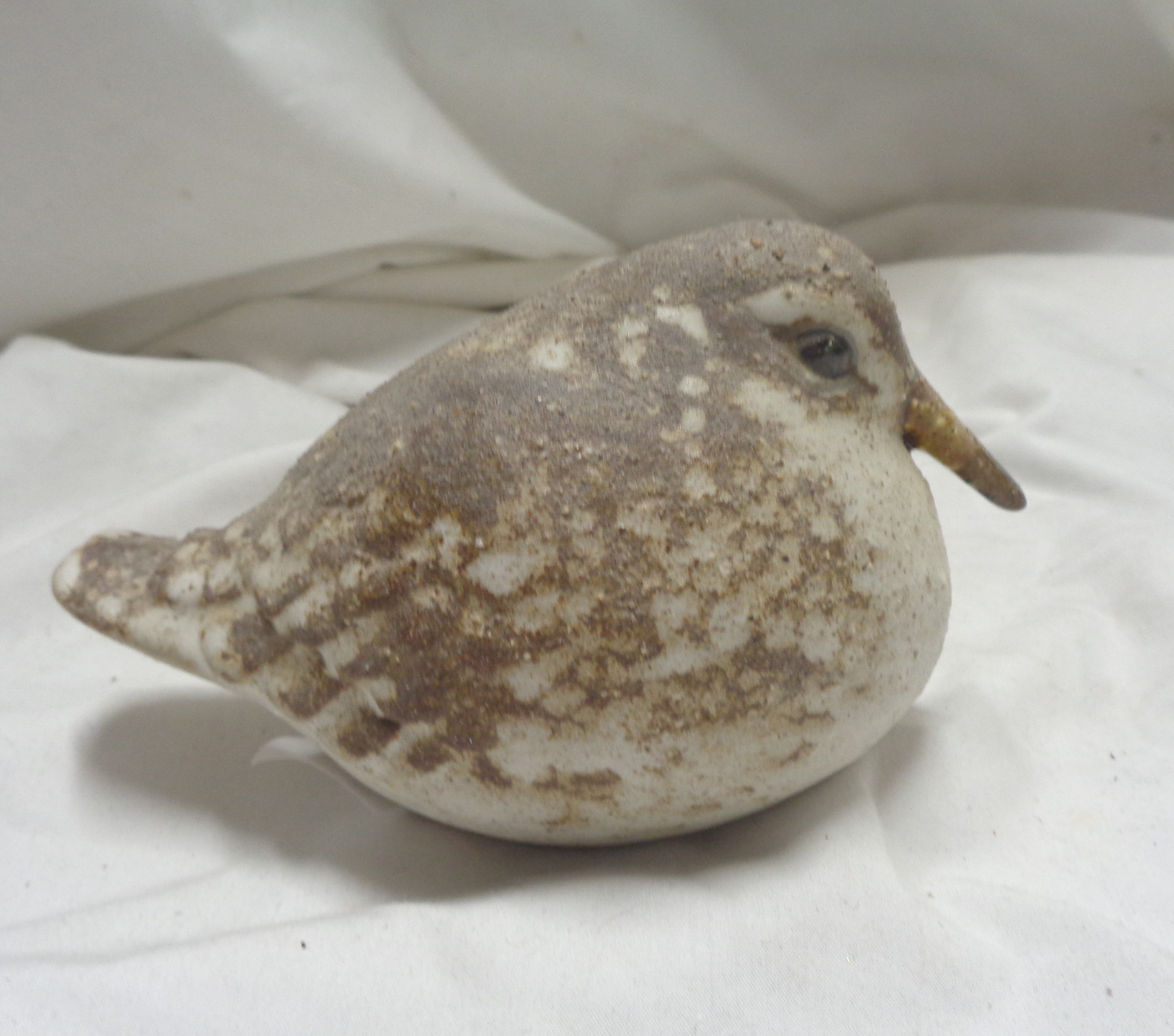 An Andersen Design Studio Pottery figurine, depicting a seated naturalistically painted bird