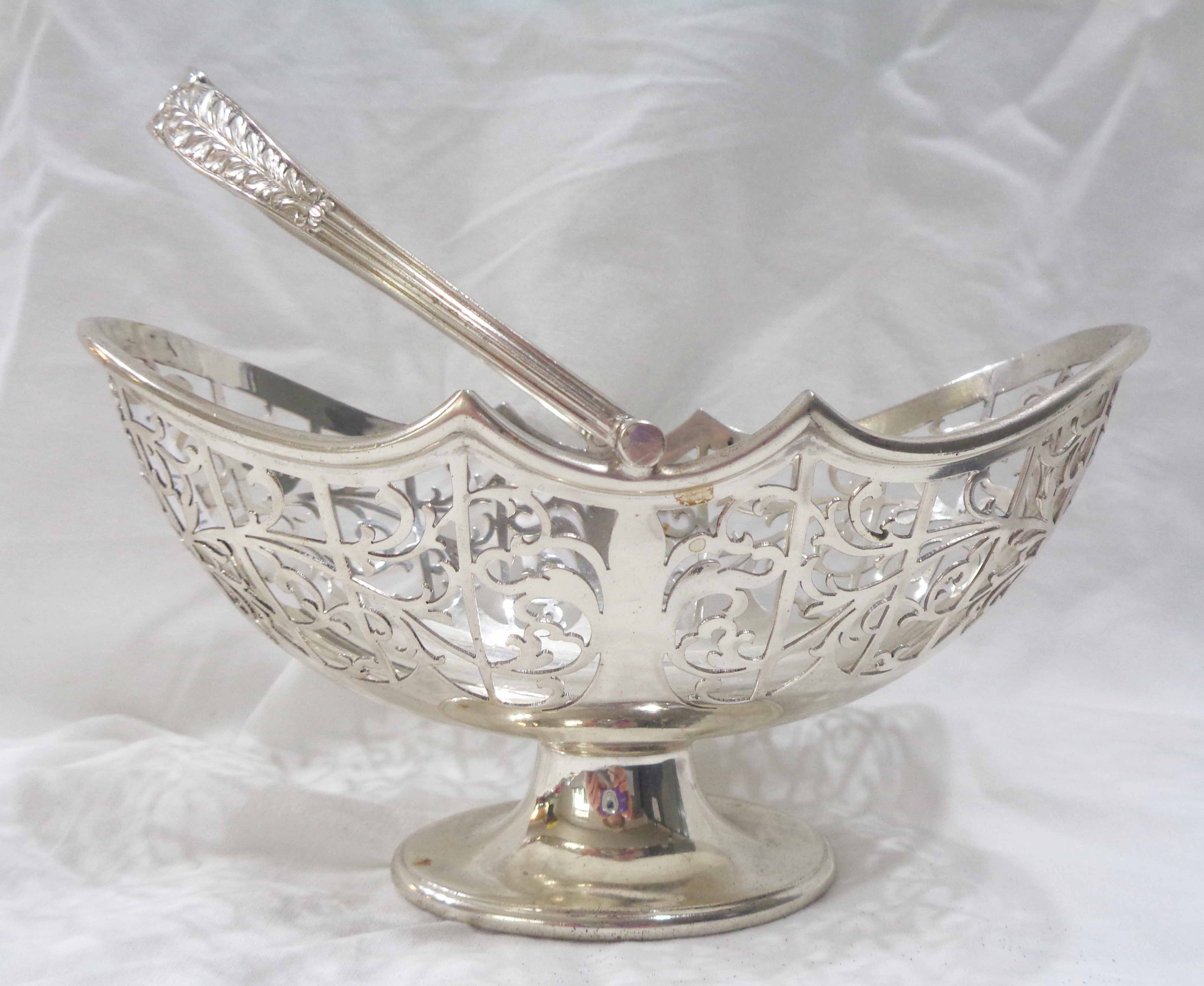 A 16.5cm silver oval pedestal basket with swing handle and pierced scroll decoration by John Round