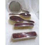 A harlequin five piece silver and tortoiseshell mounted hand mirror and brush set