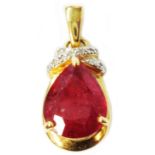 A marked 750 yellow metal pendant, set with large pear drop cut heated treated ruby and tiny