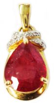 A marked 750 yellow metal pendant, set with large pear drop cut heated treated ruby and tiny