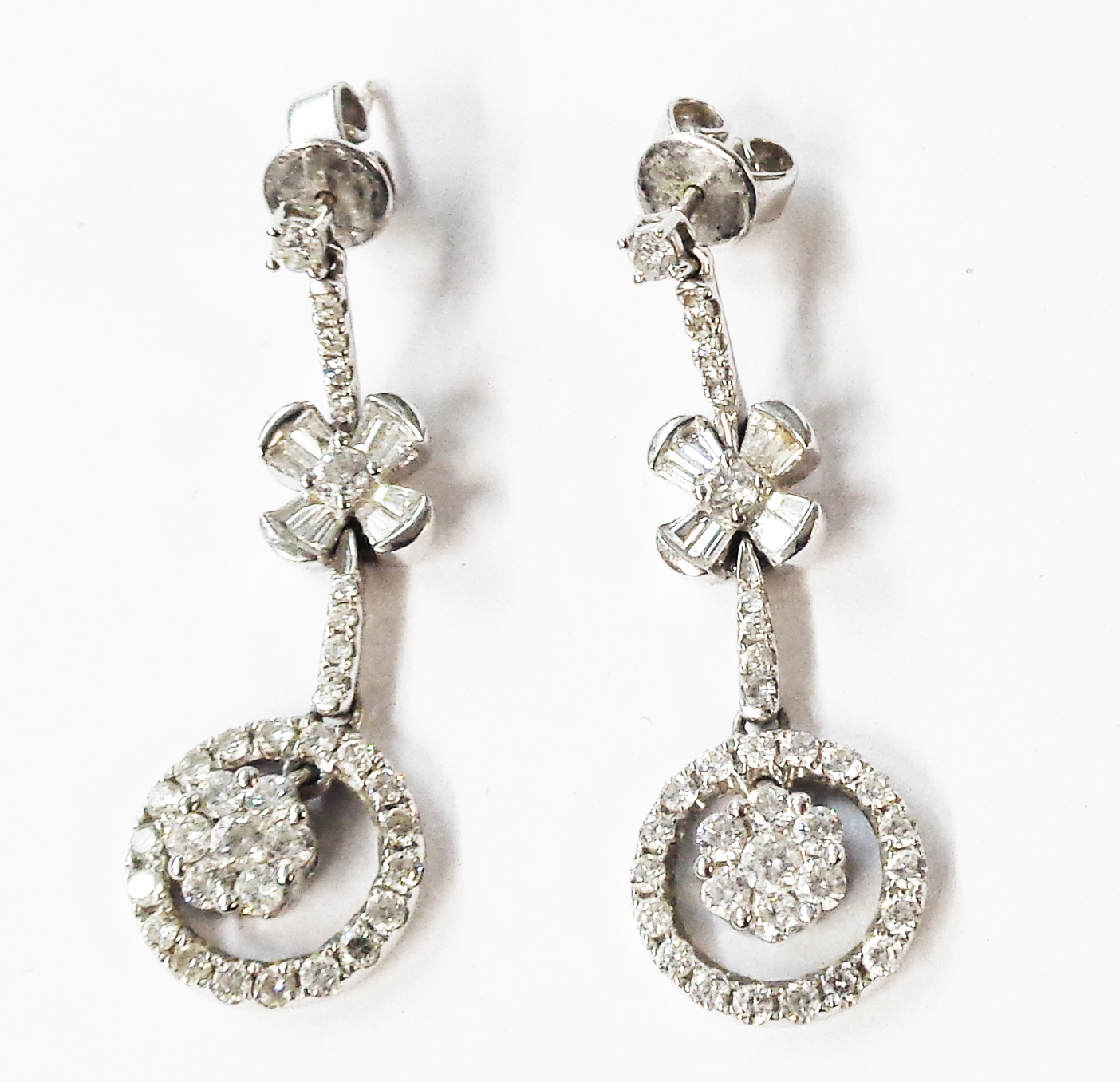 A pair of modern 1920's style 750 (18ct.) white gold diamond encrusted drop earrings with free