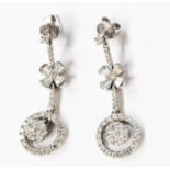 A pair of modern 1920's style 750 (18ct.) white gold diamond encrusted drop earrings with free