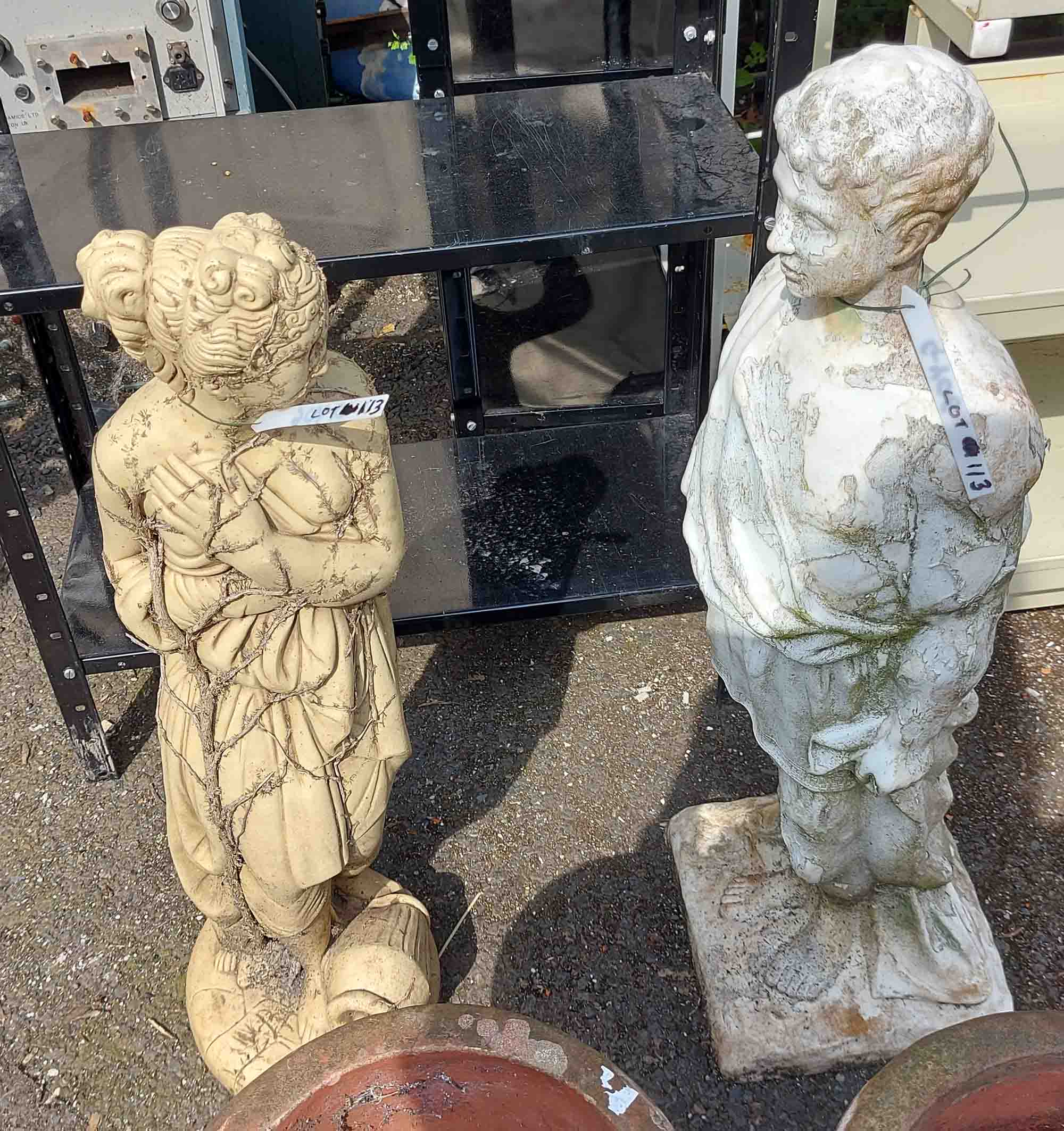 Two garden statues, depicting a man and a woman in the classical style