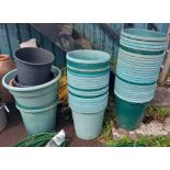 A large quantity of green plastic pots