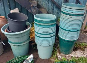 A large quantity of green plastic pots