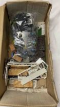 A box containing vintage toy farm pieces and accessories