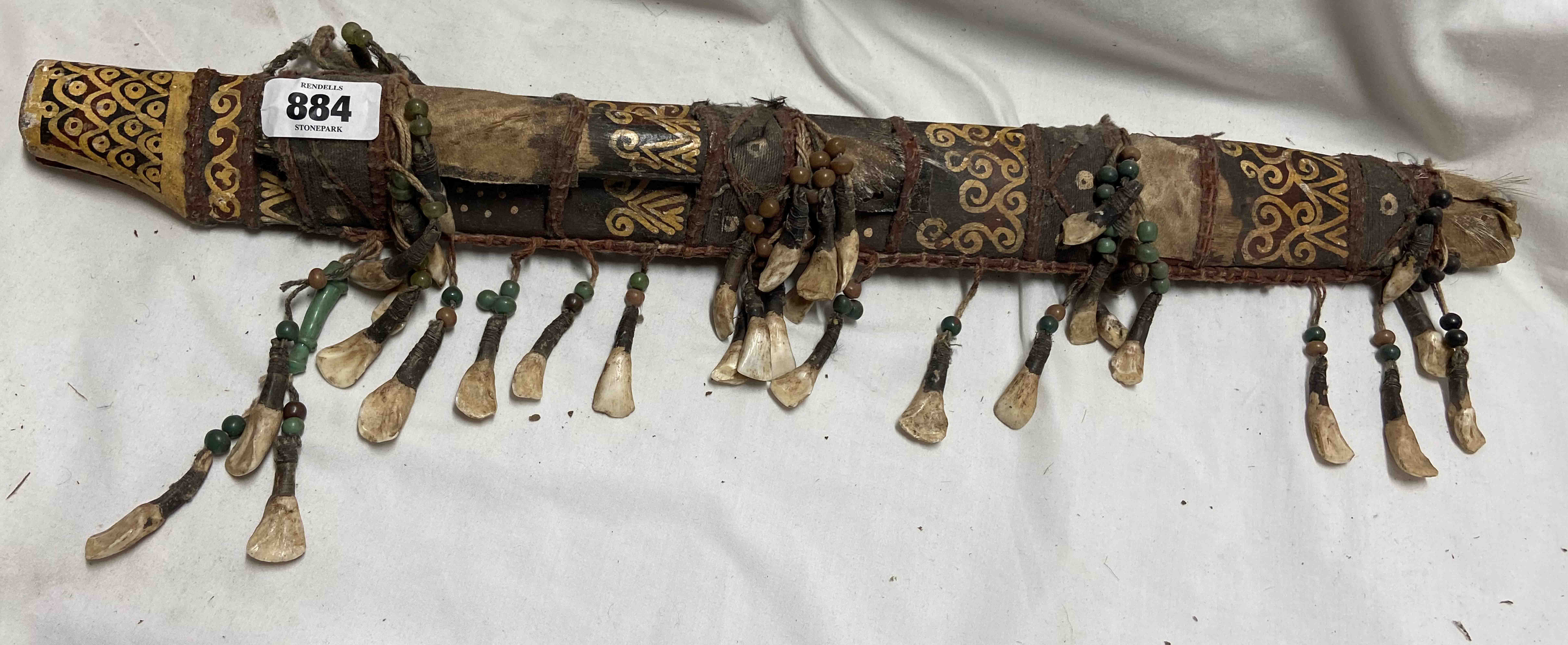 A Tibetan scabbard with tribal painted decoration and adorned with hanging teeth