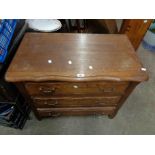 An 84cm old French oak serpentine top chest of three long drawers, set on raised feet