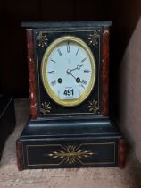A late Victorian black slate and red marble cased mantel clock with Aesthetic incised and gilded