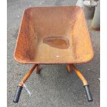 An orange painted metal wheelbarrow