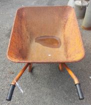 An orange painted metal wheelbarrow