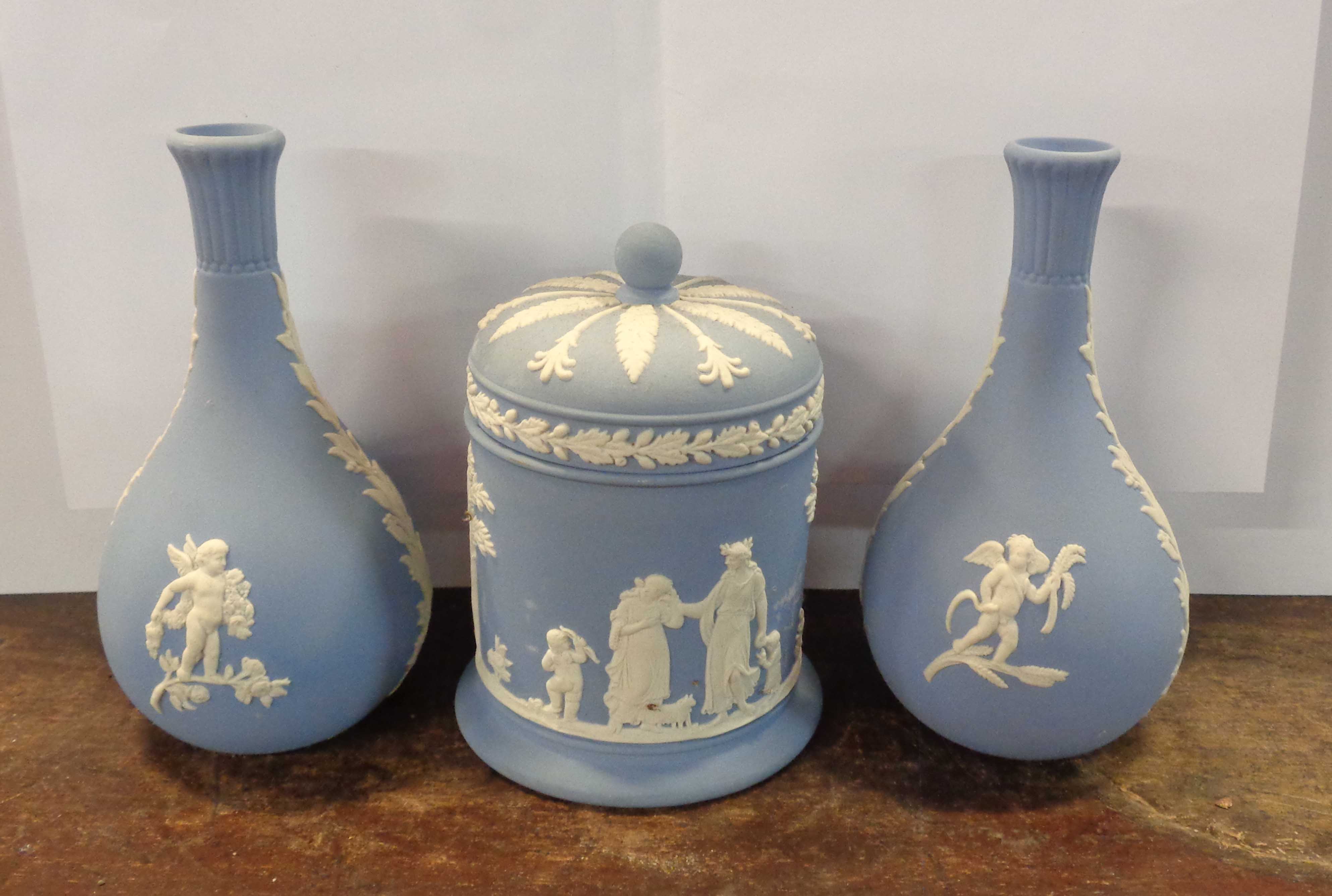 Three pieces of Wedgwood blue Jasper comprising two vases and a lidded pot