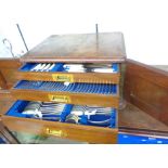 An early 20th Century walnut three drawer canteen containing a part twelve place setting of Walker &