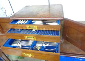 An early 20th Century walnut three drawer canteen containing a part twelve place setting of Walker &