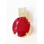 A marked 750 yellow metal pendant, set with oval heat treated ruby with tiny diamonds to suspender