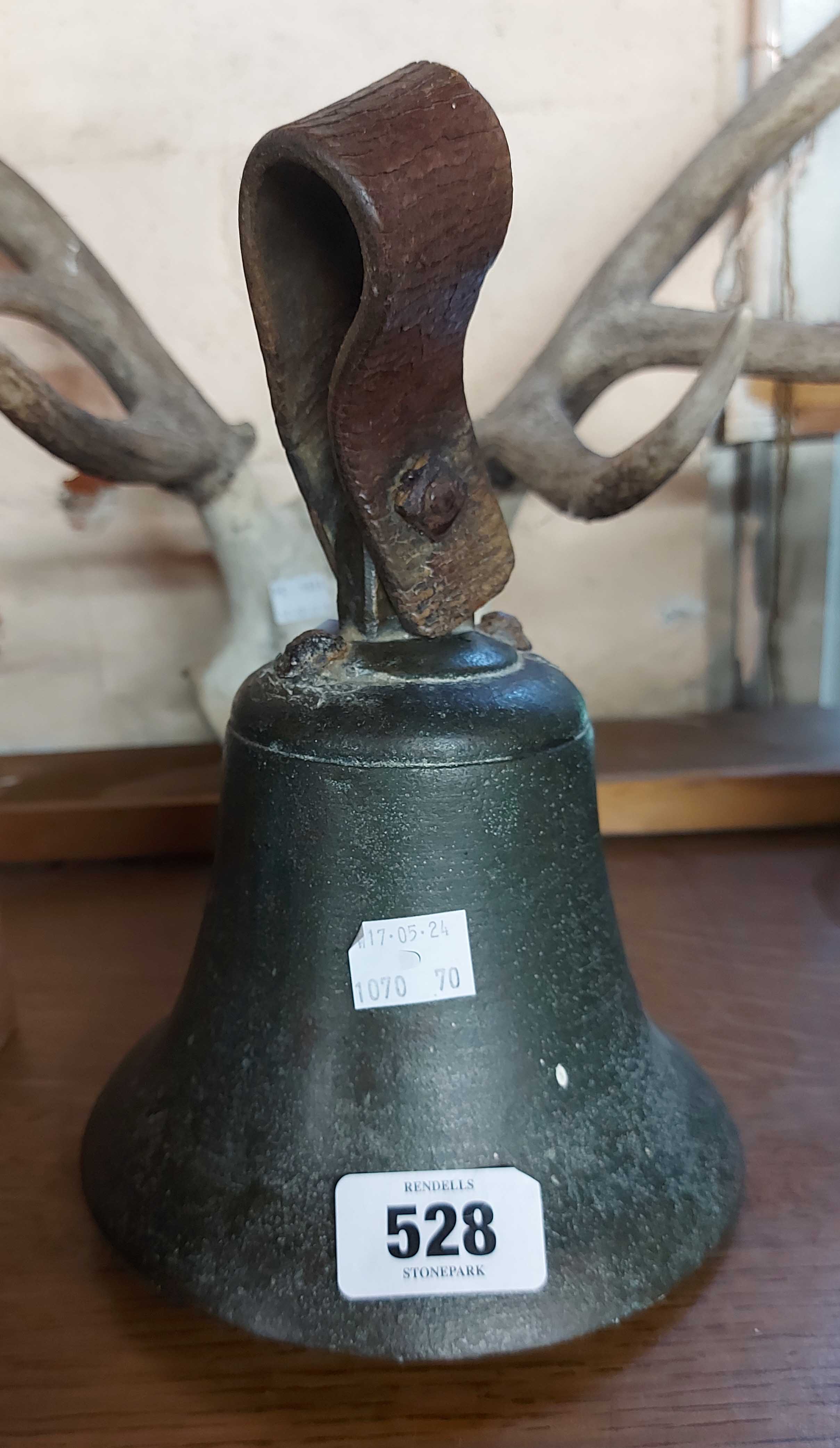 A large antique bell with leather handle