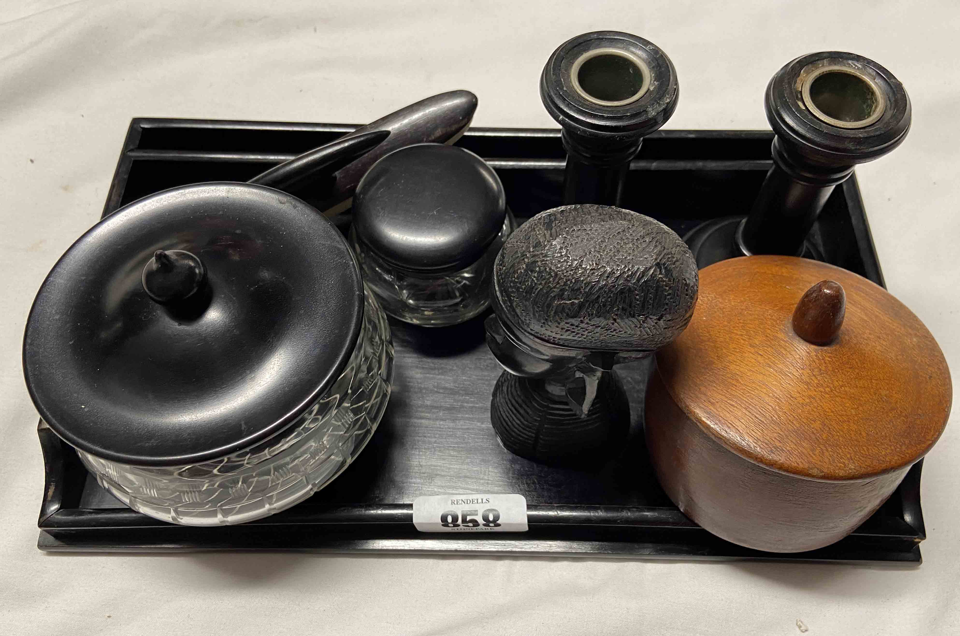 A vintage ebony and glass dressing table set comprising lidded pots and a pair of candlesticks -