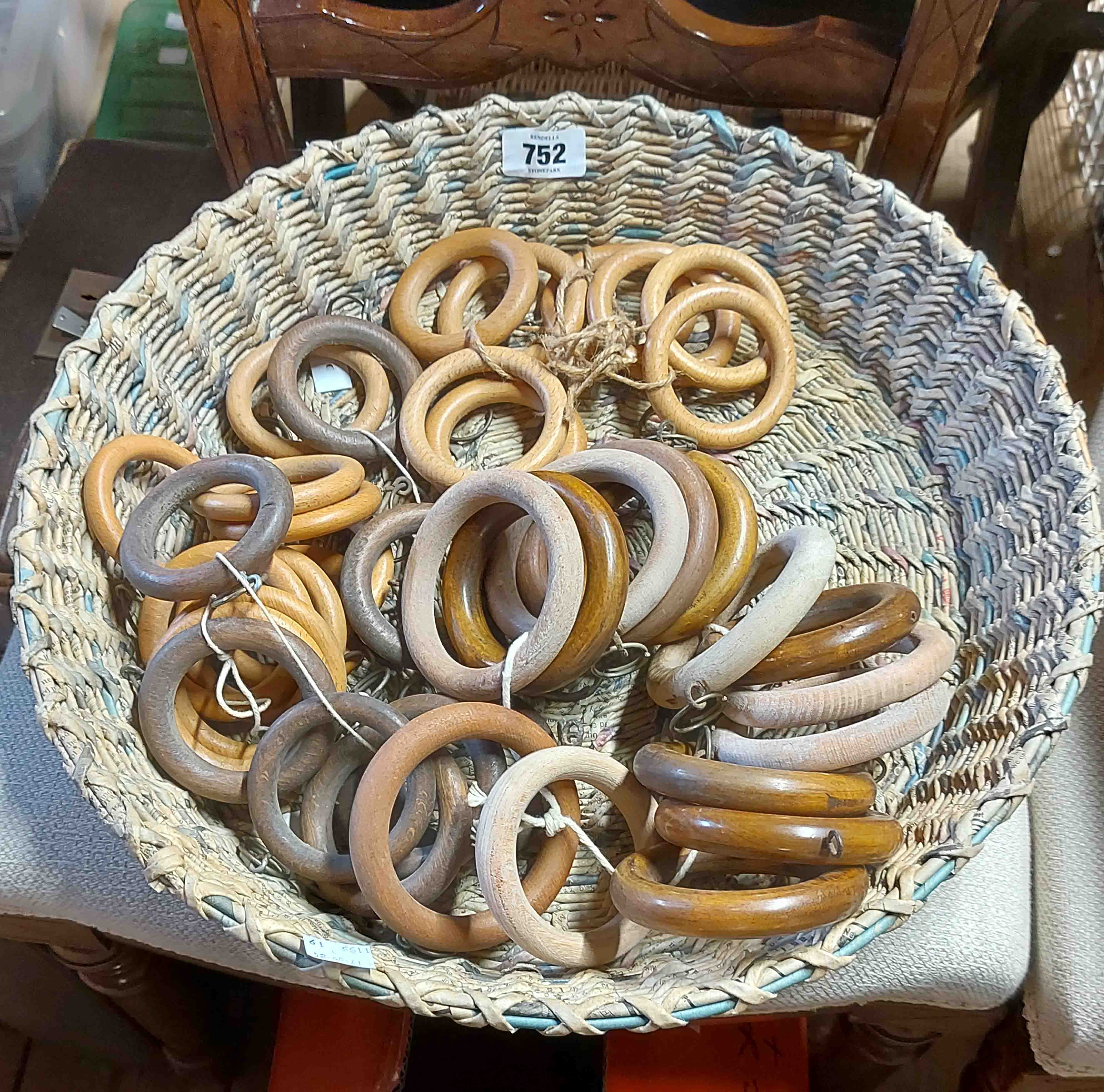 A woven basket containing a quantity of curtain rings