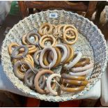 A woven basket containing a quantity of curtain rings