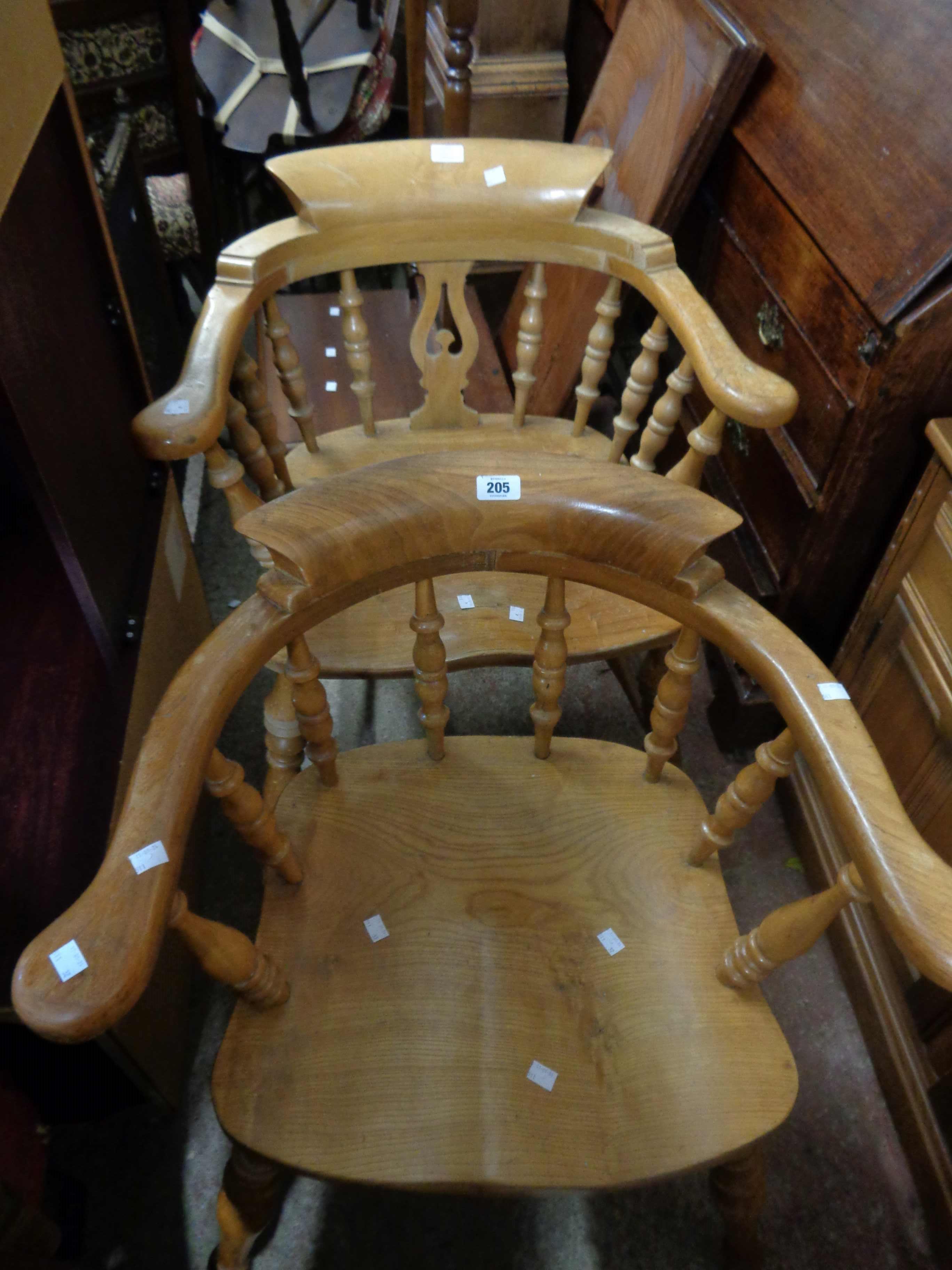 Two similar smoker's bow elbow chairs, both with moulded solid elm seats, set on turned supports