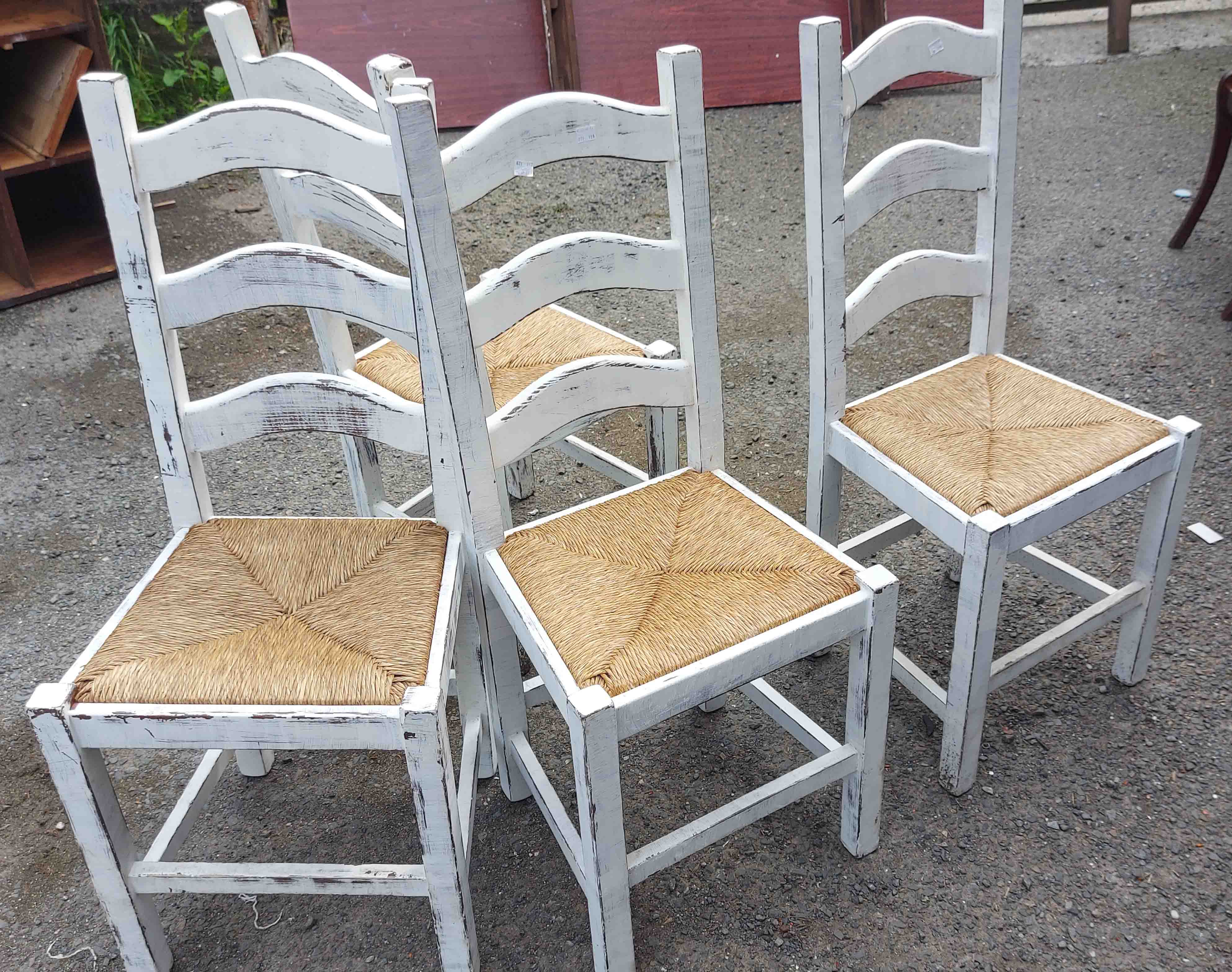 A large quantity of painted wooden chairs with rush seat