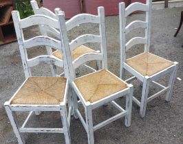 A large quantity of painted wooden chairs with rush seat