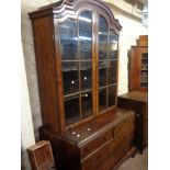 A 100cm antique Queen Anne style walnut two part book cabinet with shelves enclosed by a pair of