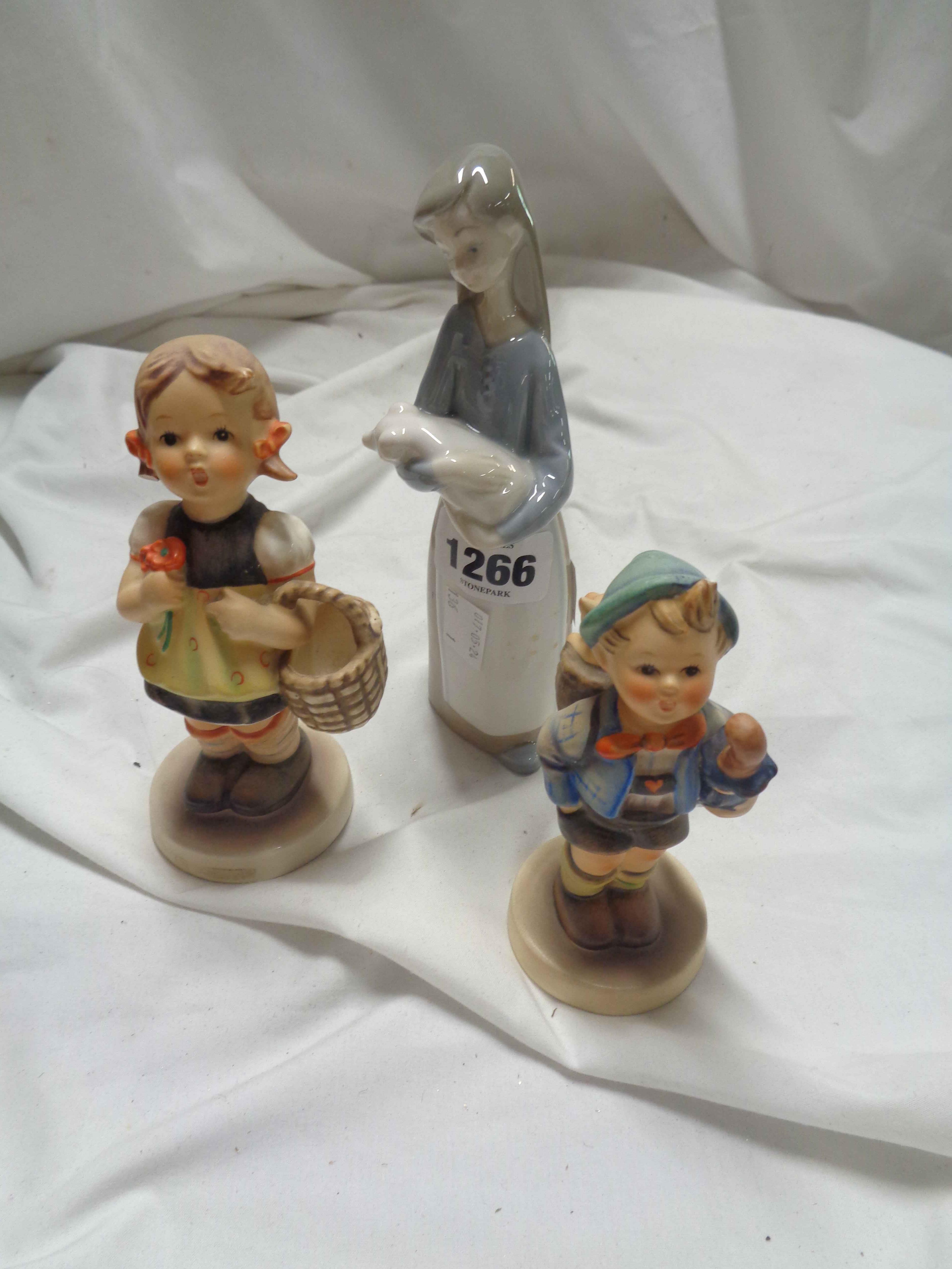 A Lladro figurine, depicting a girl holding a piglet - sold with two Hummel figures - one a/f