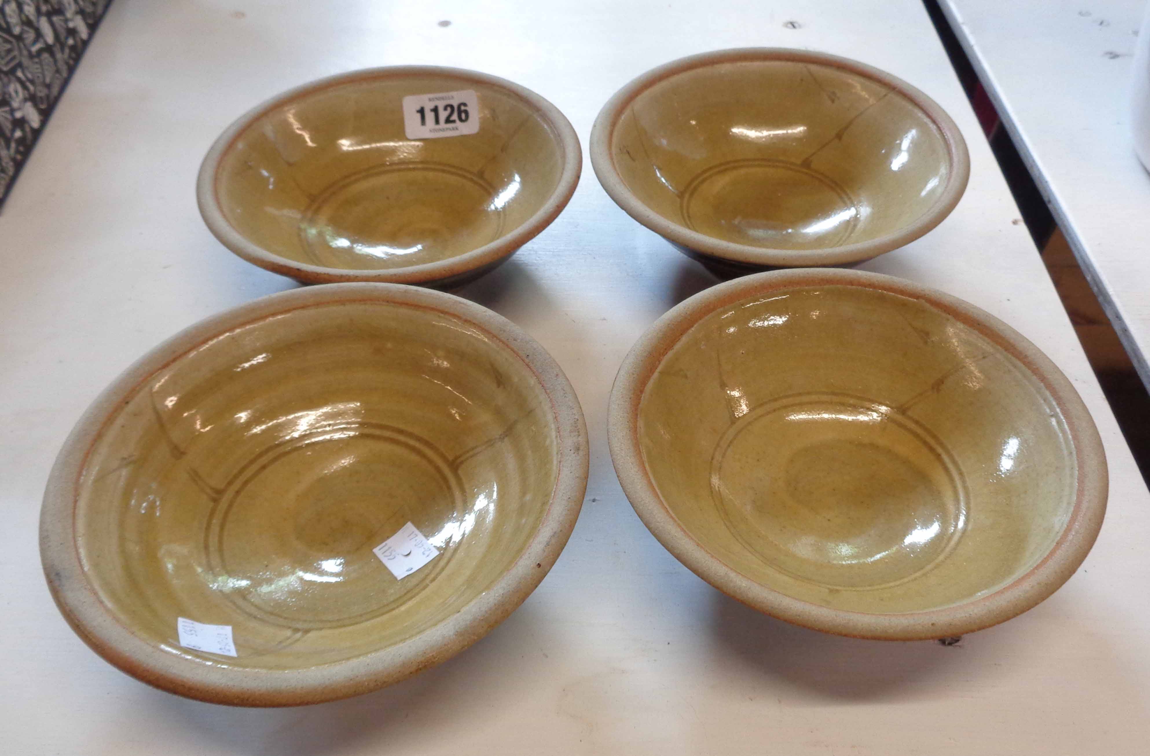 Four Studio Pottery bowls with incised decoration on a light brown interior glaze and dark brown