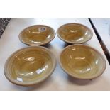 Four Studio Pottery bowls with incised decoration on a light brown interior glaze and dark brown