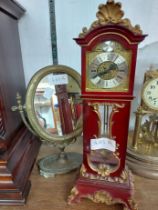 A vintage ornate burgundy and gilt resin miniature longcase timepiece with mechanical movement -