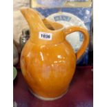 A large terracotta milk jug with brown lead glaze finish - a/f