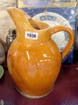 A large terracotta milk jug with brown lead glaze finish - a/f