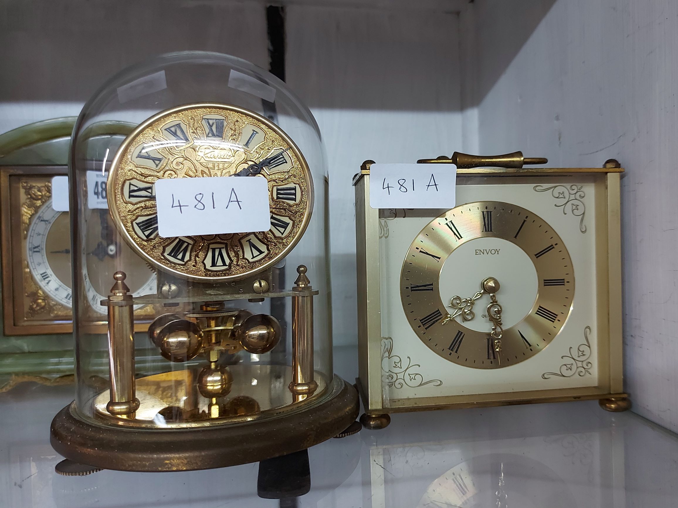 A vintage small Kundo brass anniversary clock with ball pendulum, under glass dome - sold with an