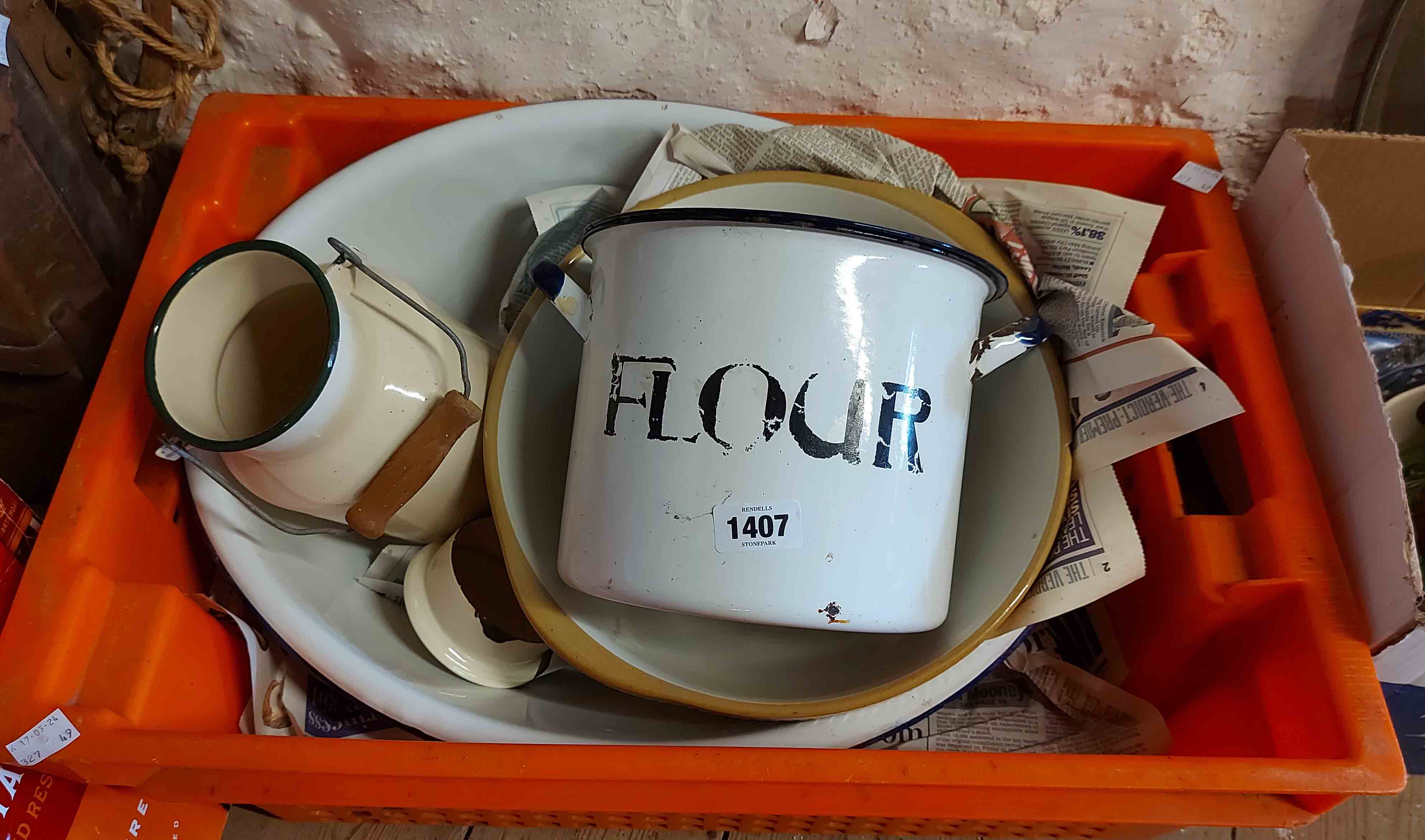 An orange crate containing a quantity of vintage enamelled kitchenware including lidded flour pot,