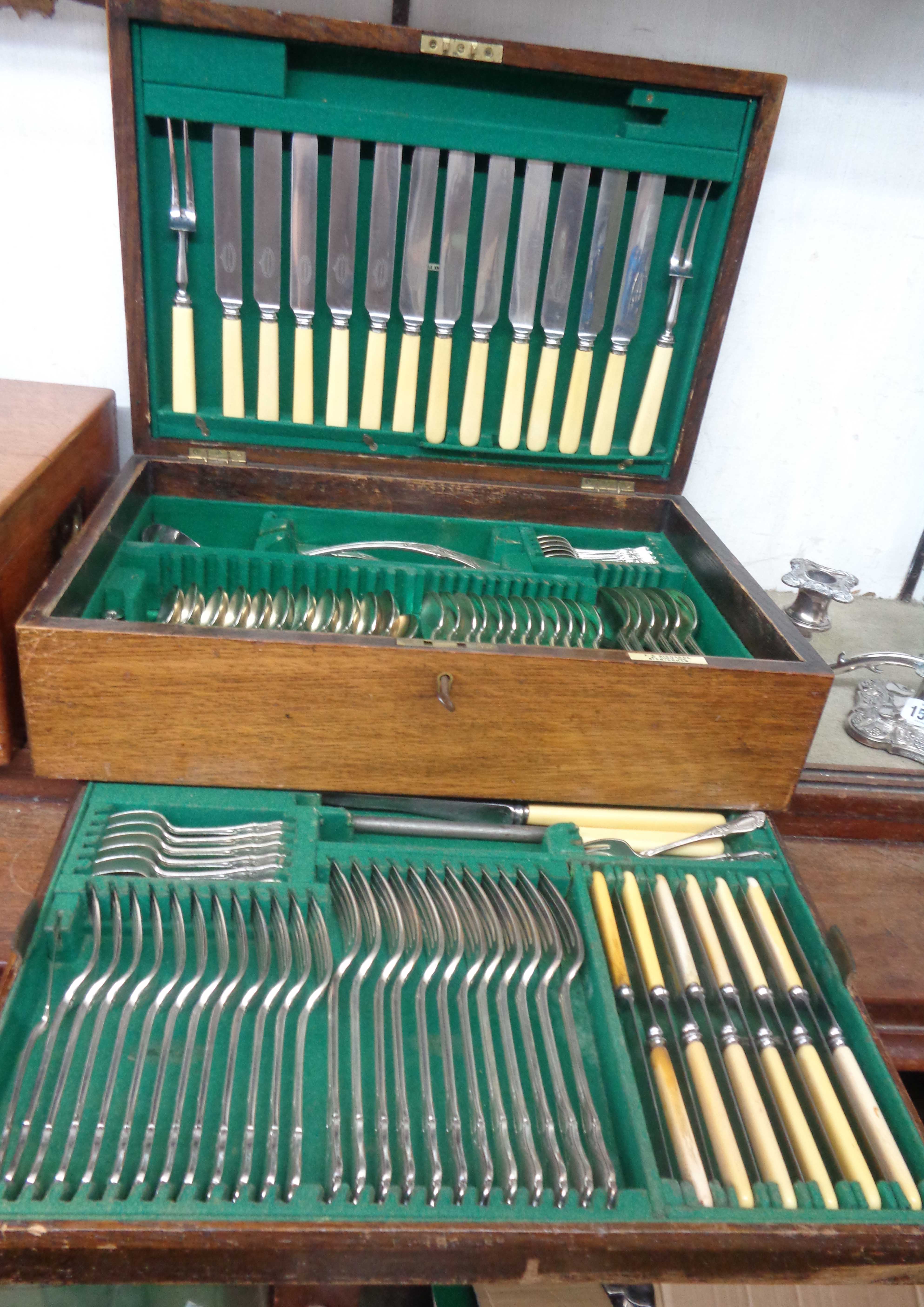 A vintage oak tray fitted canteen containing a twelve place setting of Elkington & Co. silver plated