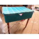 A vintage blue material upholstered lift-top sewing box with assorted contents, set on tapered
