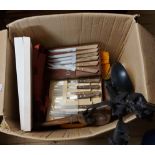 A box containing various kitchen items including steak knives, place mats, etc.