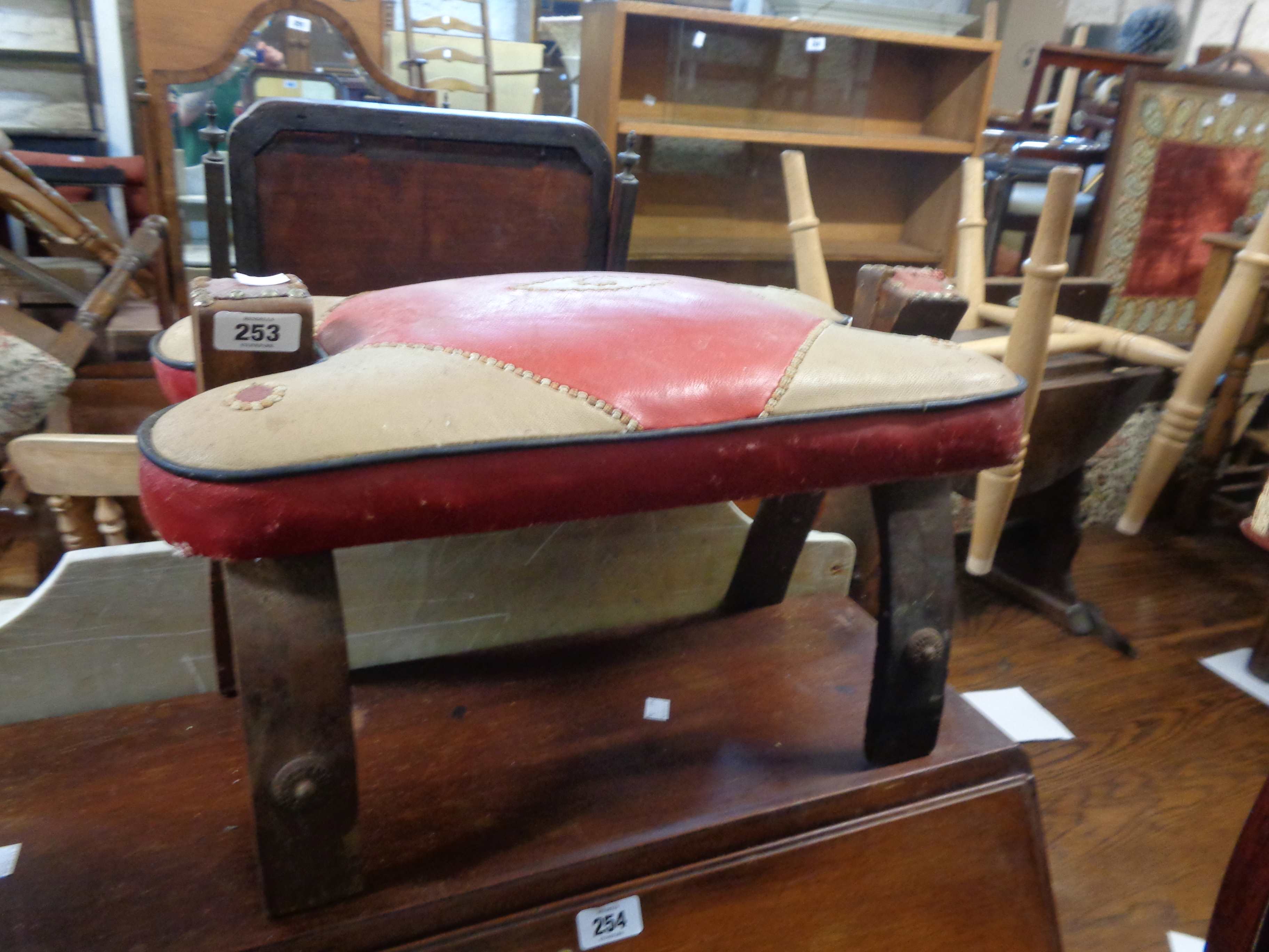 Two similar vintage camel saddle stools, both with leather upholstered seats - various condition