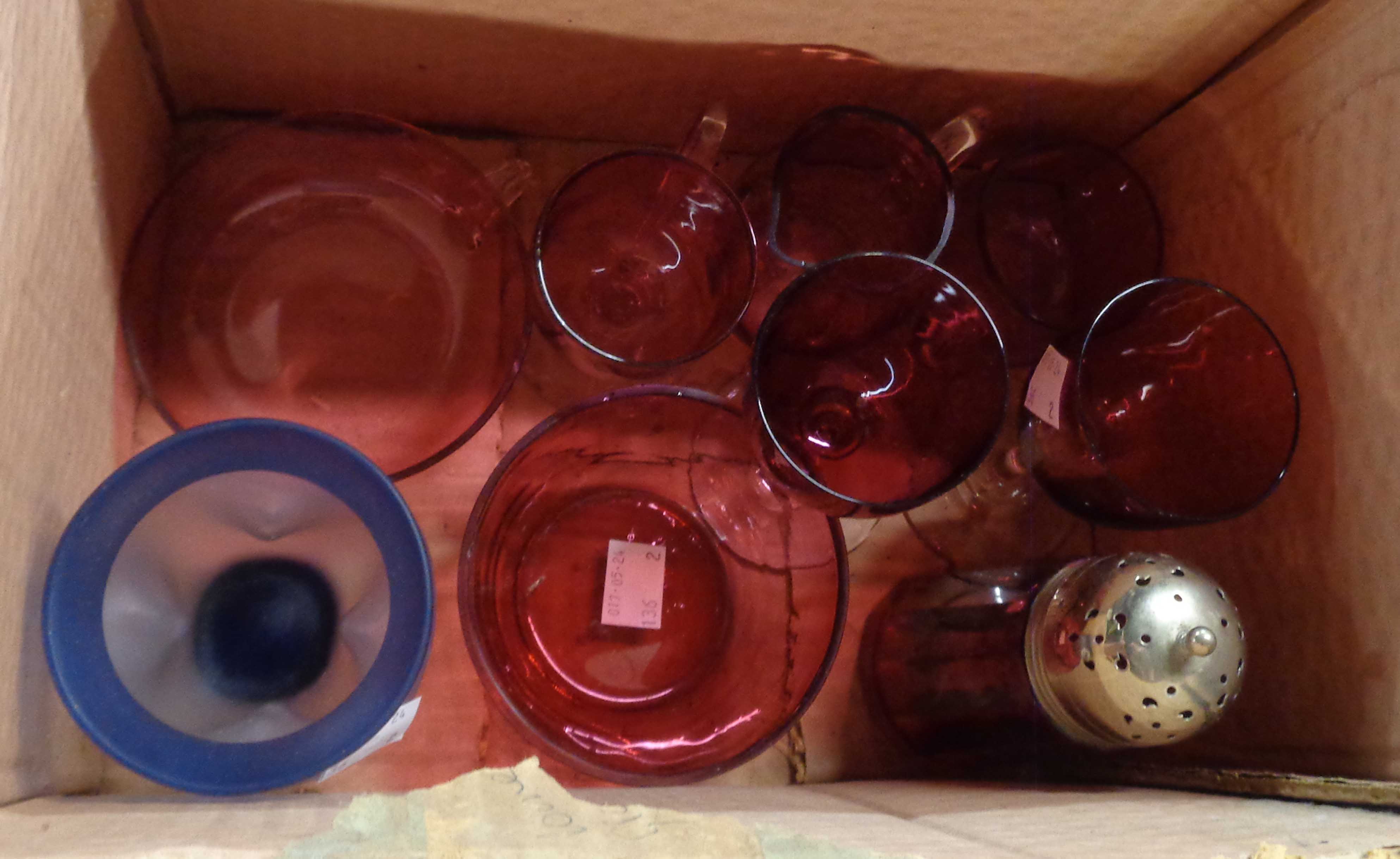 A box containing a small collection of assorted cranberry glassware including wine glasses, sugar