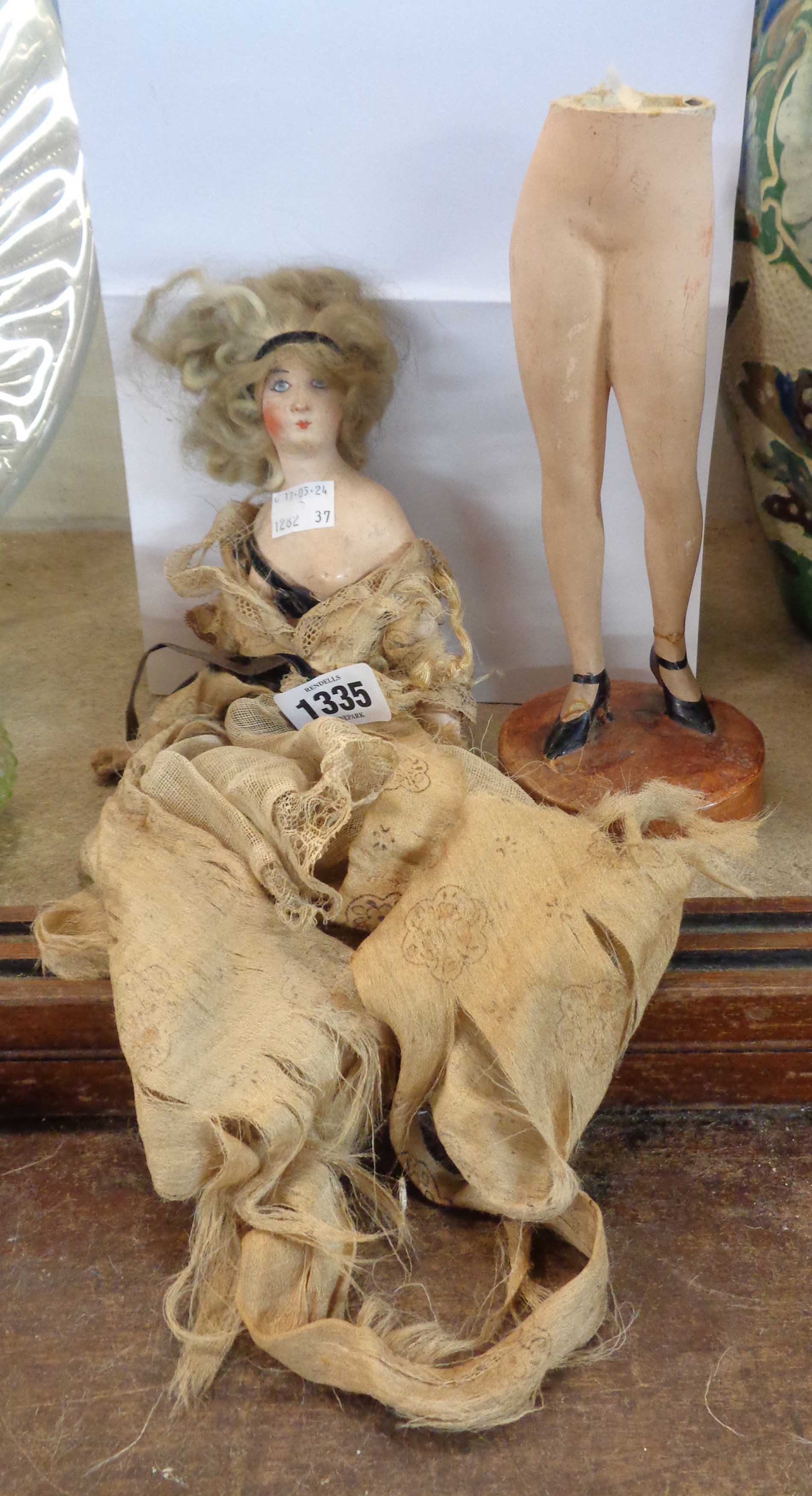 A 1920's French composition doll with remains of original clothing, hair and a painted face -