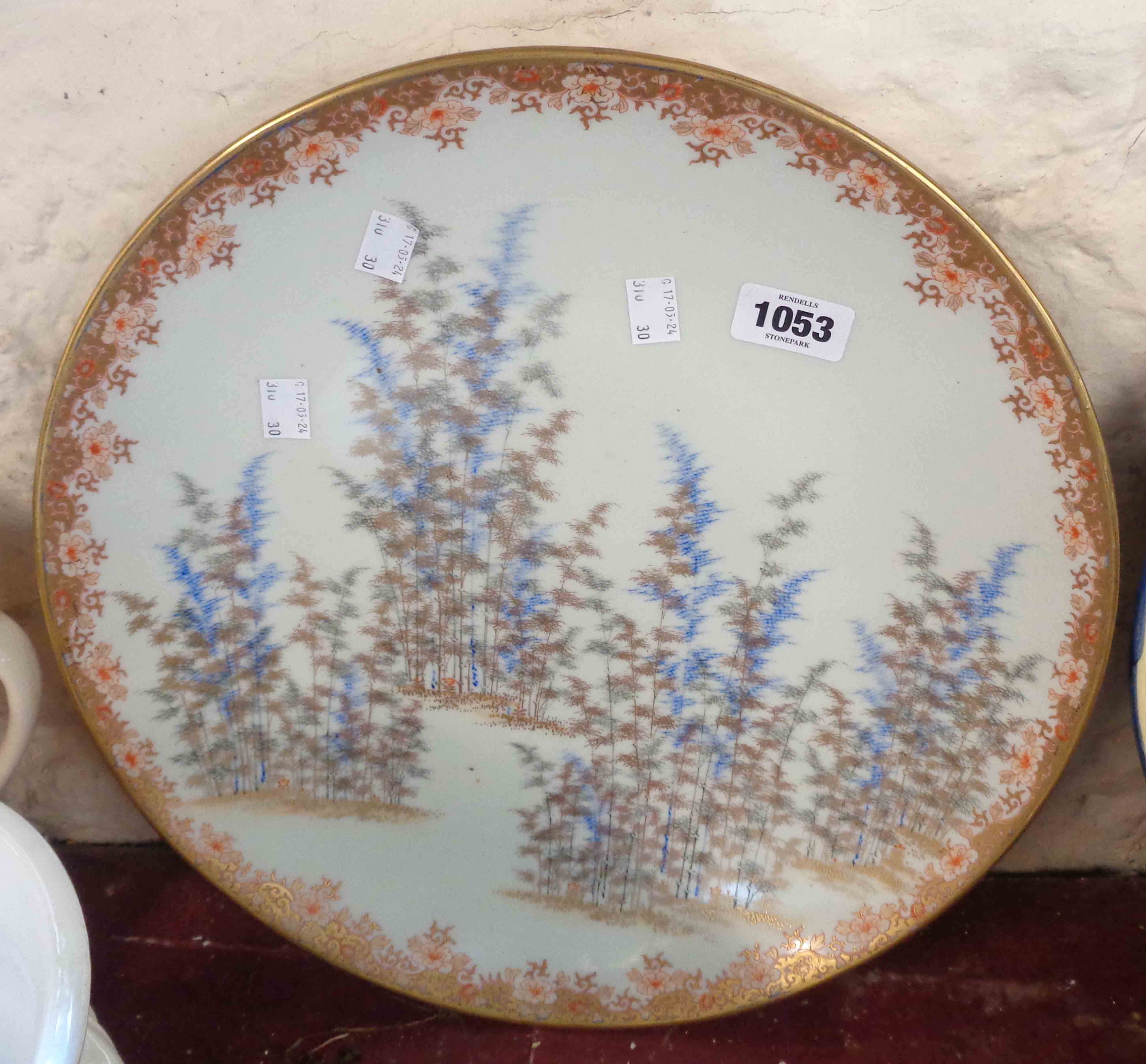 A large early 20th Century Japanese porcelain charger with hand painted decoration, depicting bamboo