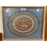A framed 20th Century Chinese circular embroidered textile panel with central flowers and butterfly